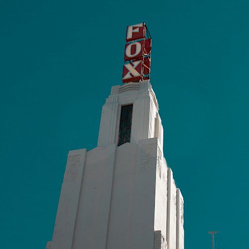 This image shows the top of an Art Deco-style building with a sign that reads 